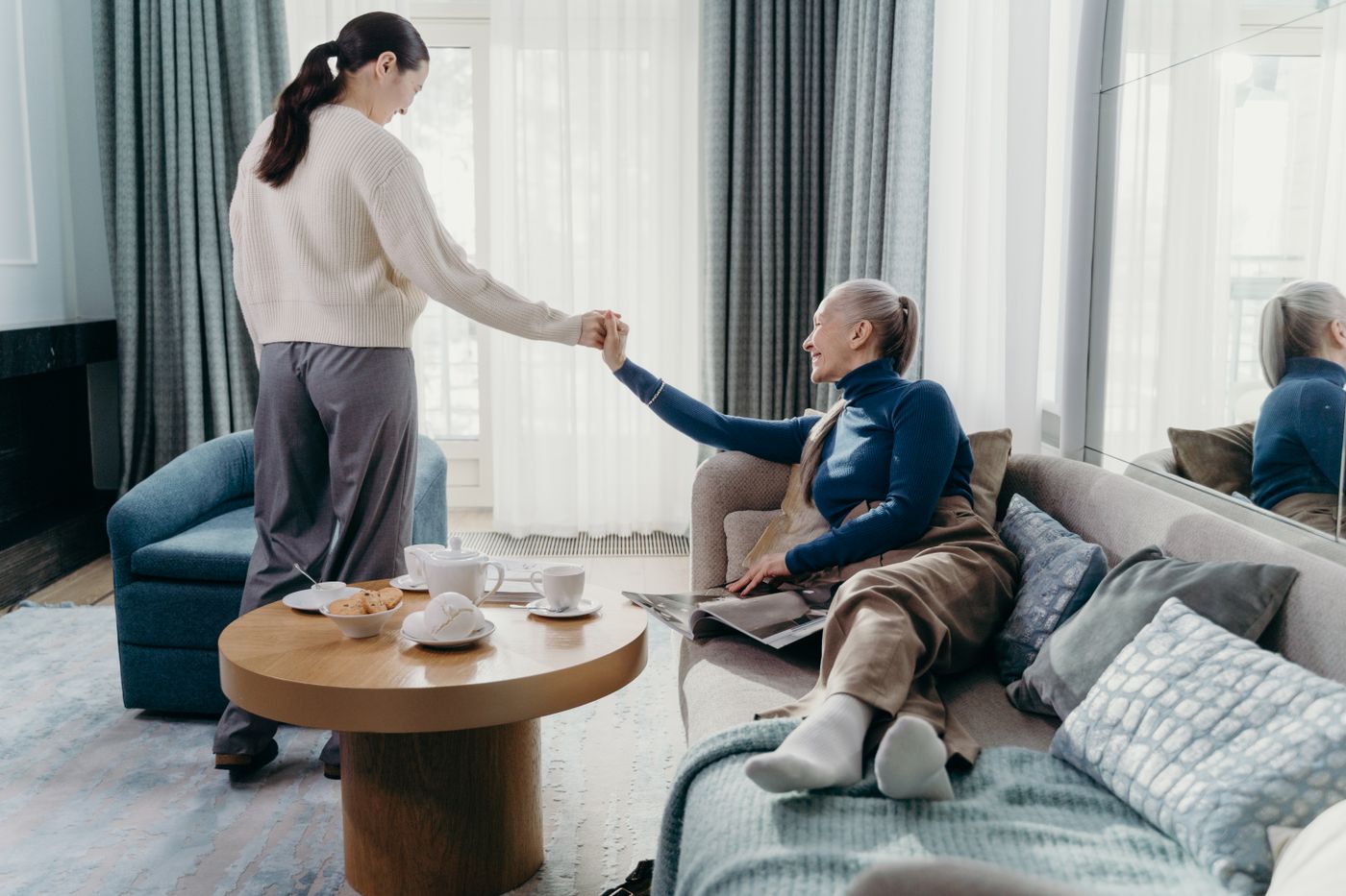 A caregiver helping a resident in a bright, comfortable living room